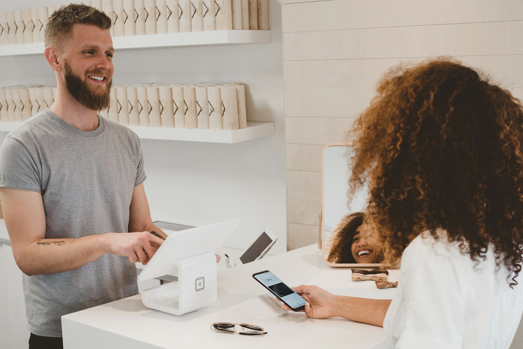Mağazada POS terminaliyle ödeme yapan müşteri ve satış görevlisi